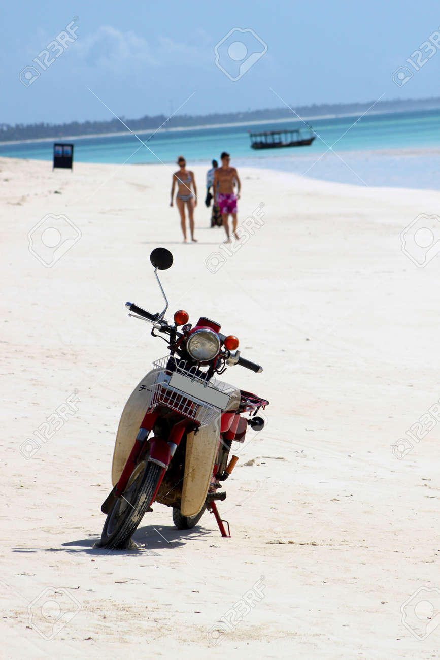 Un Scooter Abandonné Stationné Sur Une Plage De Sable Blanc Plage Paradisiaque De Zanzibar Avec Des Eaux Bleues