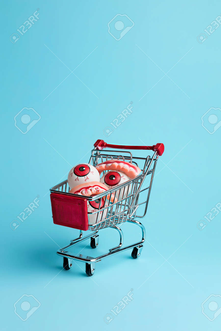 Creative layout made with eyeballs in shopping cart. Minimal Halloween shopping background. Invitation card, party, copy space. - 157117758 Creative layout made with eyeballs in shopping cart. Minimal Halloween shopping background. Invitation card, party, copy space. - 157117758