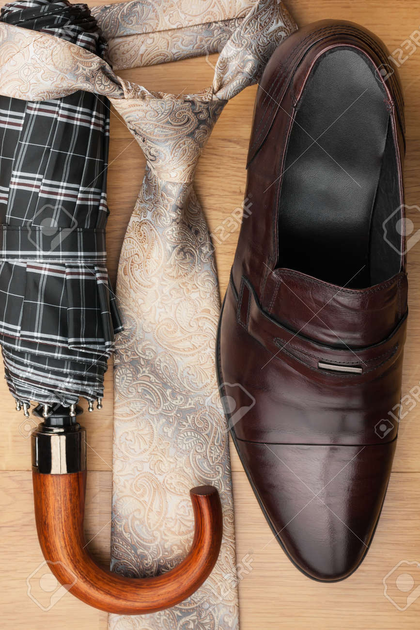 Zapatos de los hombres clásicos, Corbata, paraguas y bolso en el piso de madera, se pueden utilizar como fondo Zapatos de los hombres clásicos, Corbata, paraguas y bolso en el piso de madera, se pueden utilizar como fondo