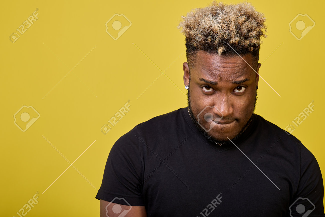 A Dark-skinned Guy With Curly Hair Looks Guiltily Pursed By Pursing His  Lips. A Stylish Young Man Feels Guilty For Committing A Bad Offense Stands  With A Guilty Look Фотография, картинки, изображения