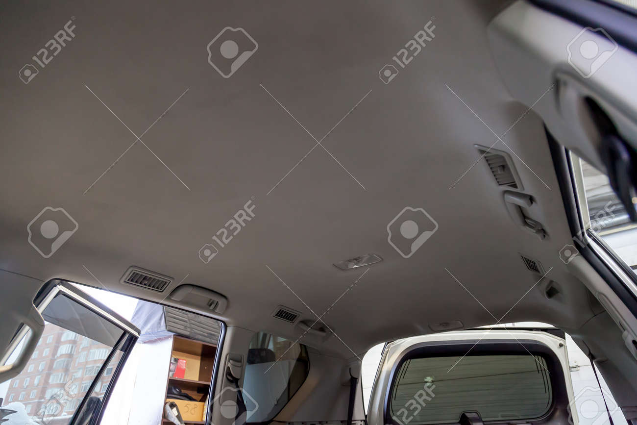 Light beige ceiling in the cabin of the SUV after dry cleaning and seasonal inspection in the workshop for repair and maintenance of vehicles. - 114358426 Light beige ceiling in the cabin of the SUV after dry cleaning and seasonal inspection in the workshop for repair and maintenance of vehicles. - 114358426