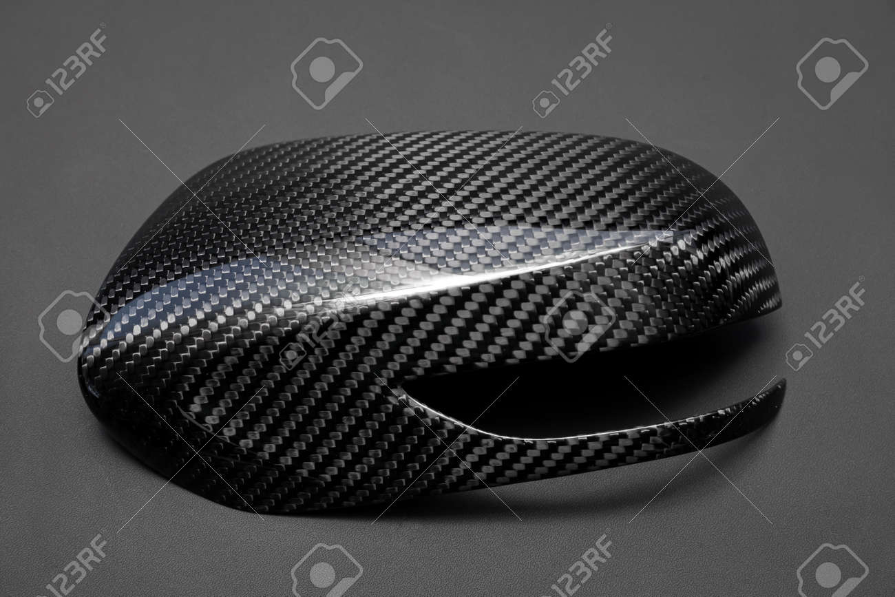 A close-up on a car exterior mirror made from carbon fiber of interwoven black and gray color from heavy-duty yarns for the production of light and durable elements in industry. Tuning body parts. - 138529494 A close-up on a car exterior mirror made from carbon fiber of interwoven black and gray color from heavy-duty yarns for the production of light and durable elements in industry. Tuning body parts. - 138529494