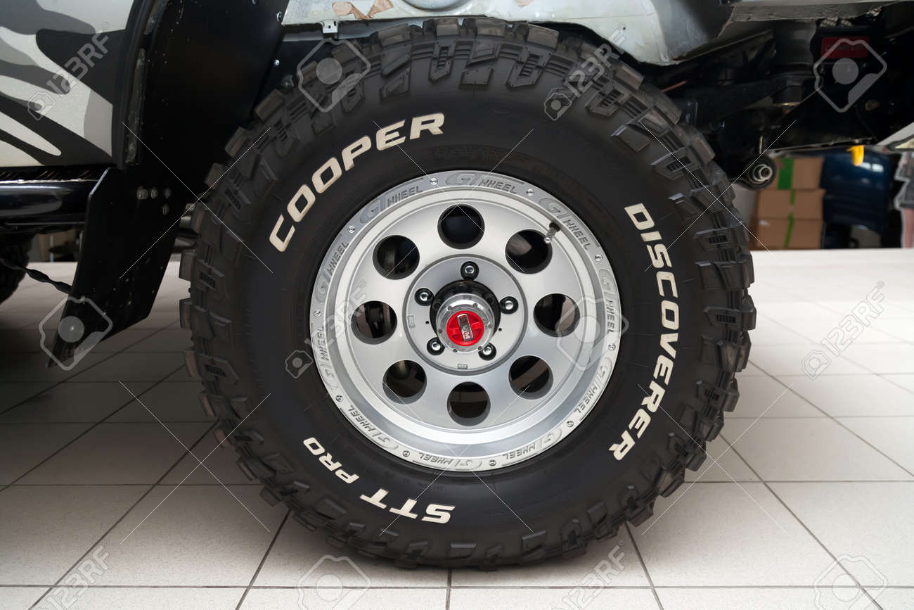 Novosibirsk, Russia - 02.26.2020: The most extreme all-season, off-road tire Cooper Discoverer STT Pro with AVM hubs off-road performance, tread design, tire durability on the wheel disk. - 141315404 Novosibirsk, Russia - 02.26.2020: The most extreme all-season, off-road tire Cooper Discoverer STT Pro with AVM hubs off-road performance, tread design, tire durability on the wheel disk. - 141315404