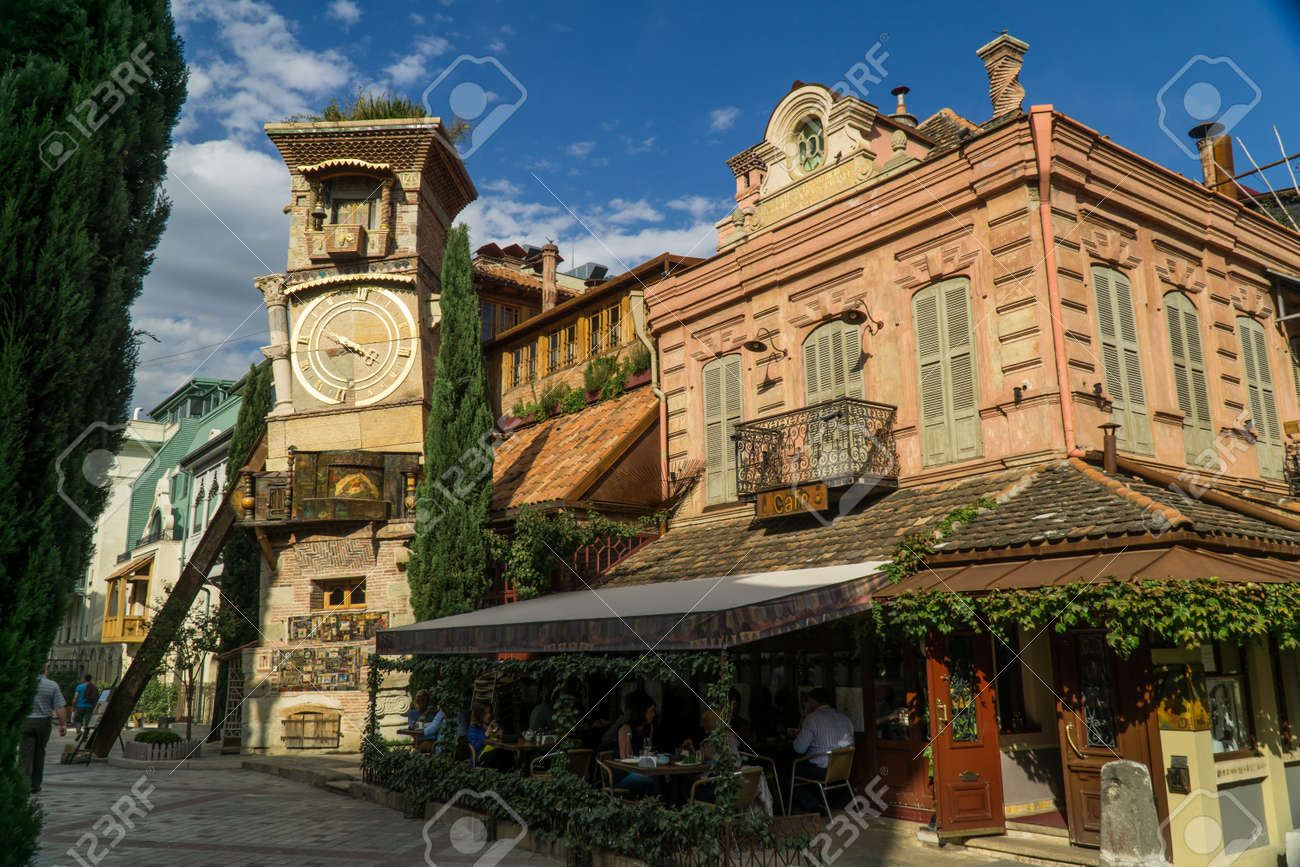 TBILISI, GEORGIA - SEP 25, 2016: The leaning clock tower of Rezo Gabriadze Marionette Theatre with the art cafe from the right. - 77282282 TBILISI, GEORGIA - SEP 25, 2016: The leaning clock tower of Rezo Gabriadze Marionette Theatre with the art cafe from the right. - 77282282