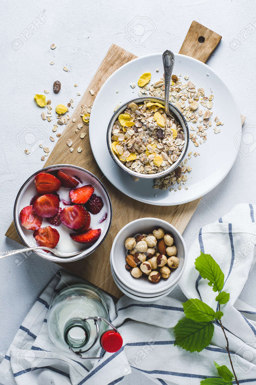 Muesli with fresh strawberries in a plate over a white concrete background - 83876194 Muesli with fresh strawberries in a plate over a white concrete background - 83876194