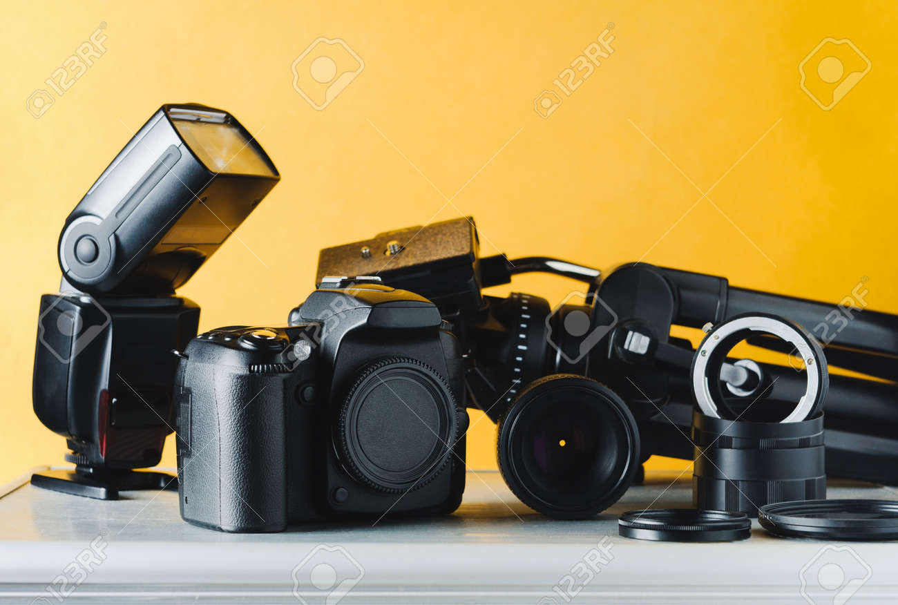 Digital camera, lenses and equipment of the photographer on a yellow background - 85167952 Digital camera, lenses and equipment of the photographer on a yellow background - 85167952