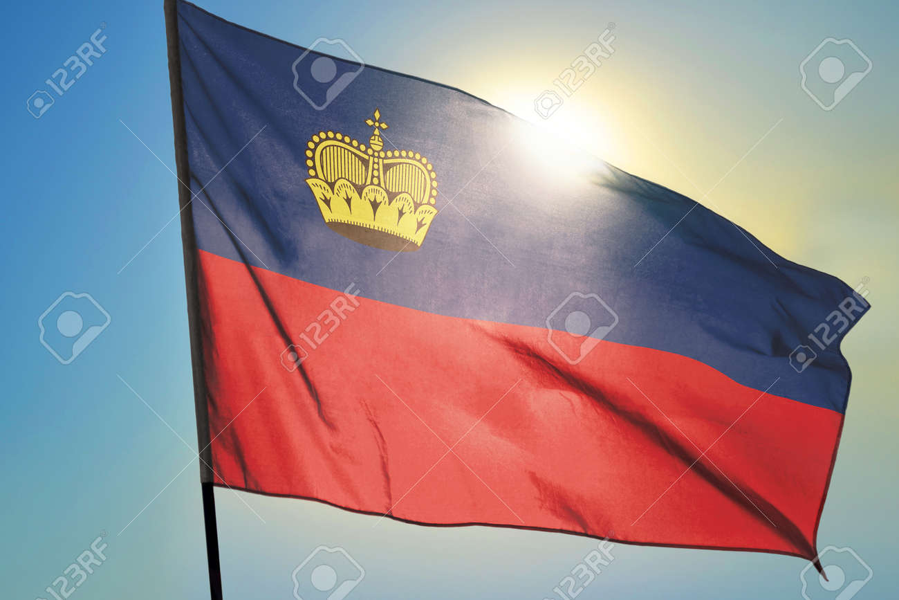 Liechtenstein flag waving on the wind in front of sun - 166480096 Liechtenstein flag waving on the wind in front of sun - 166480096