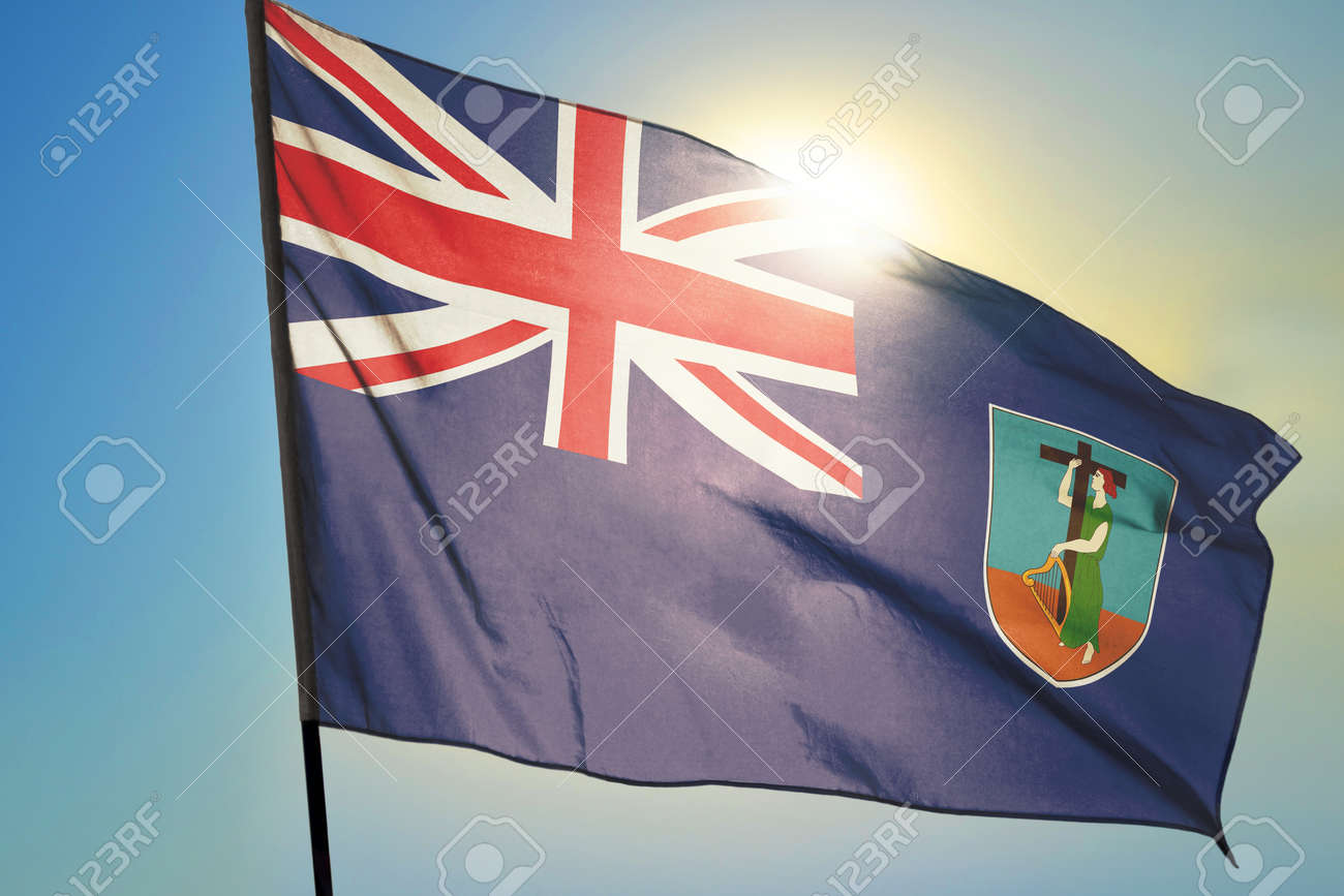 Montserrat flag waving on the wind in front of sun - 166480113 Montserrat flag waving on the wind in front of sun - 166480113