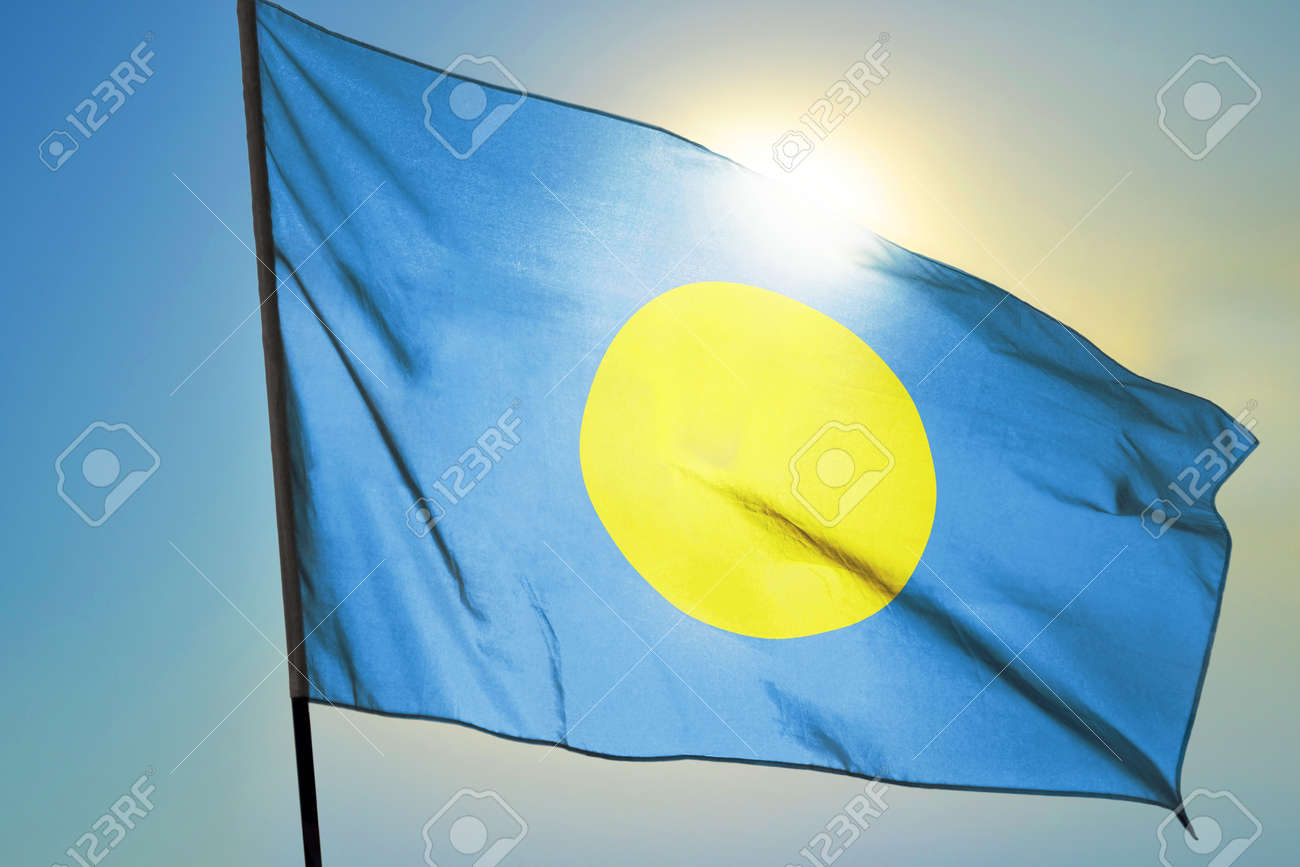 Palau flag waving on the wind in front of sun - 166480126 Palau flag waving on the wind in front of sun - 166480126
