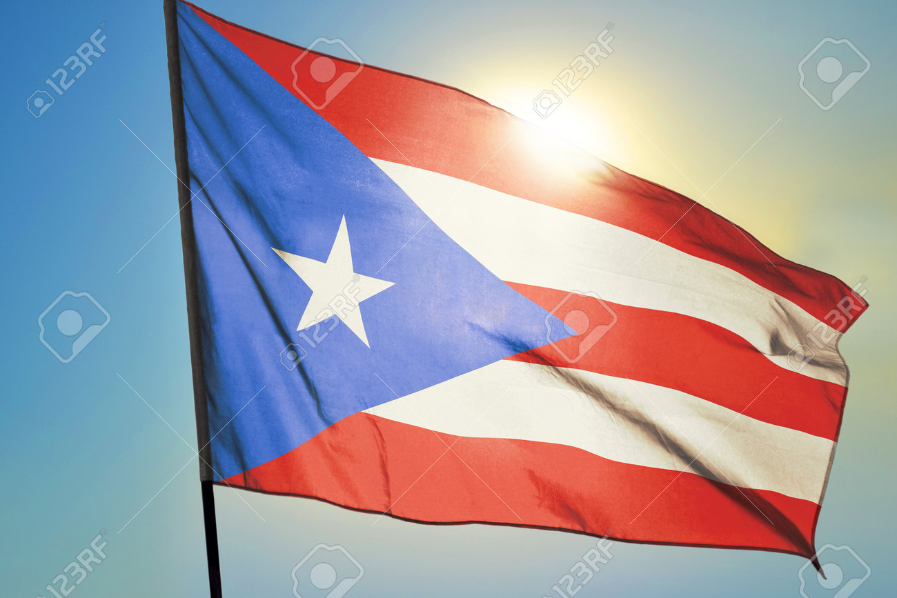 Puerto Rico flag waving on the wind in front of sun - 166480131 Puerto Rico flag waving on the wind in front of sun - 166480131