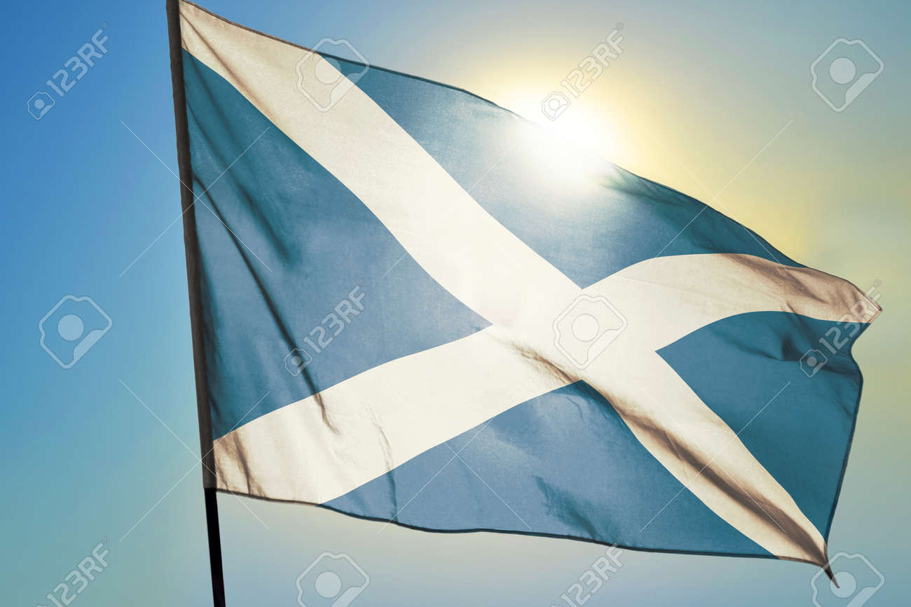 Scotland flag waving on the wind in front of sun - 166480140 Scotland flag waving on the wind in front of sun - 166480140