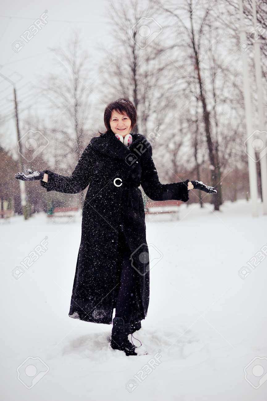 屋外では雪遊びが黒い毛皮のコートで冬の女性 の写真素材 画像素材 Image