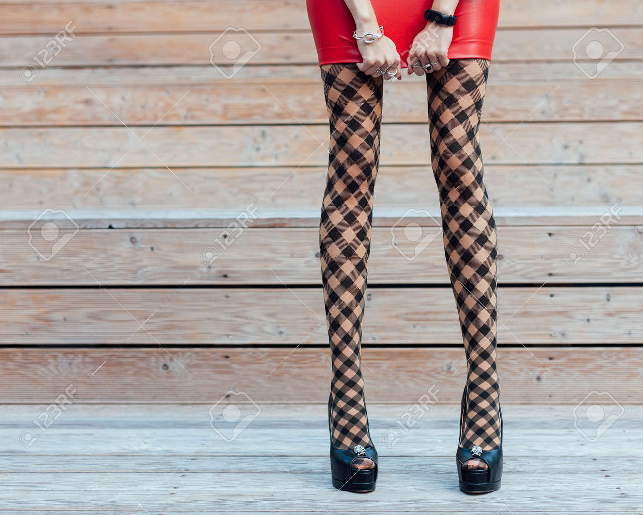 ファッション ファッショナブルな網タイツ 短い赤い革スカート 黒のハイヒールの靴で 長い脚と非常にセクシーな女の子は 彼女のスカートを調整します 体の部分 の写真素材 画像素材 Image 8785
