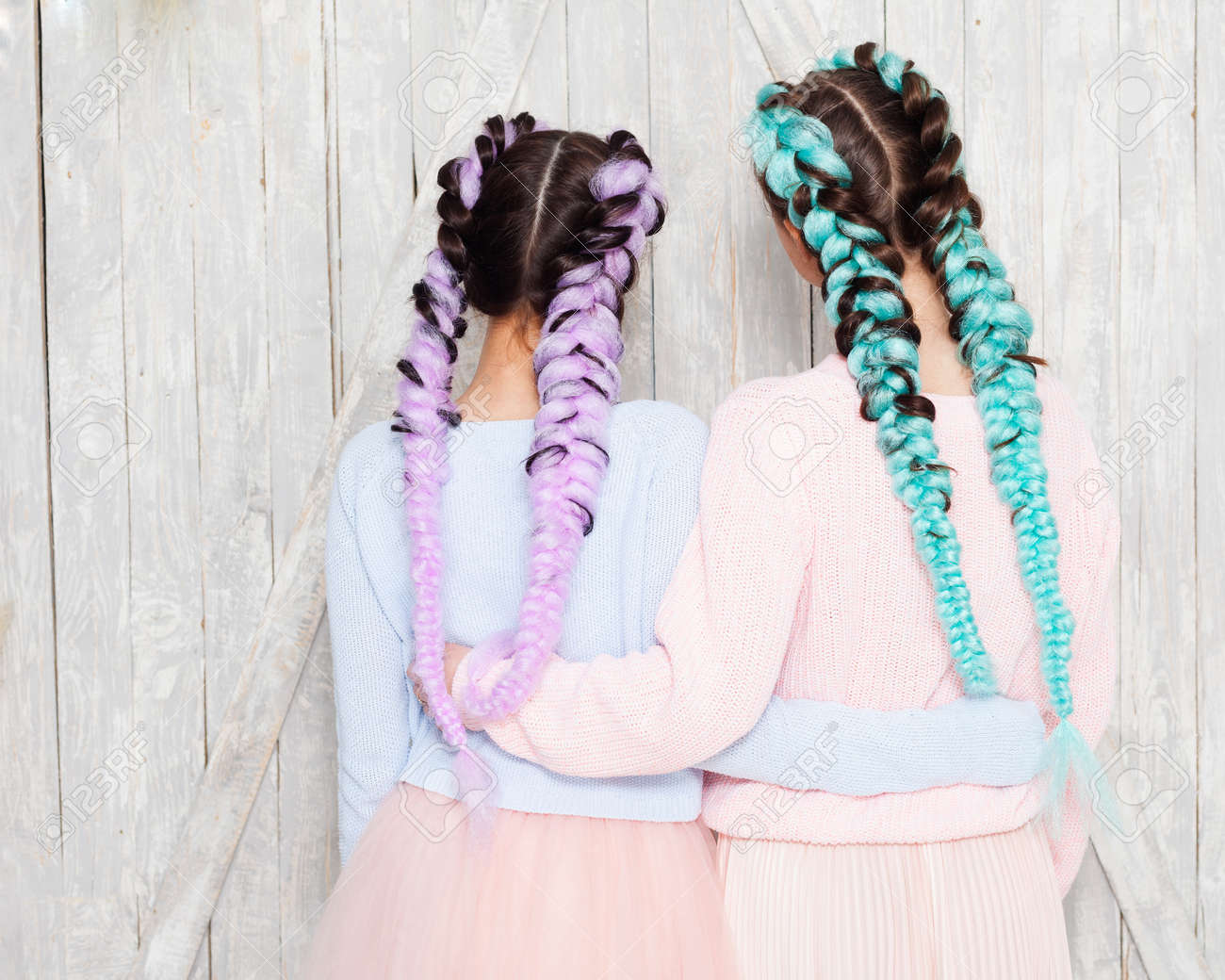 ガールフレンド 色付きの三つ編みをしたファッション衣装を着た2人の女の子がカメラに背中を抱きしめています 屋内 の写真素材 画像素材 Image