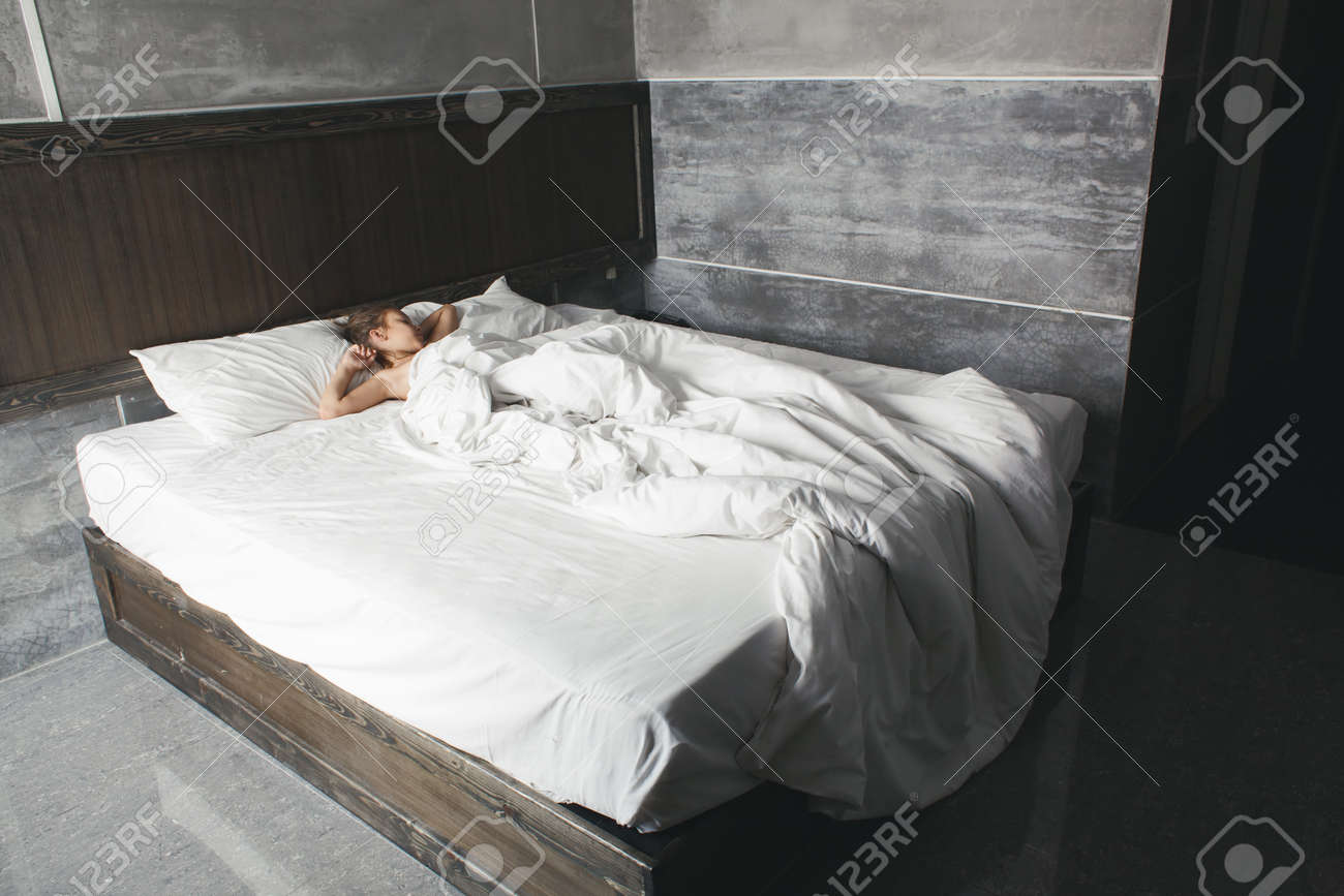 girl resting on a bed in luxury hotel with modern concrete design girl resting on a bed in luxury hotel with modern concrete design