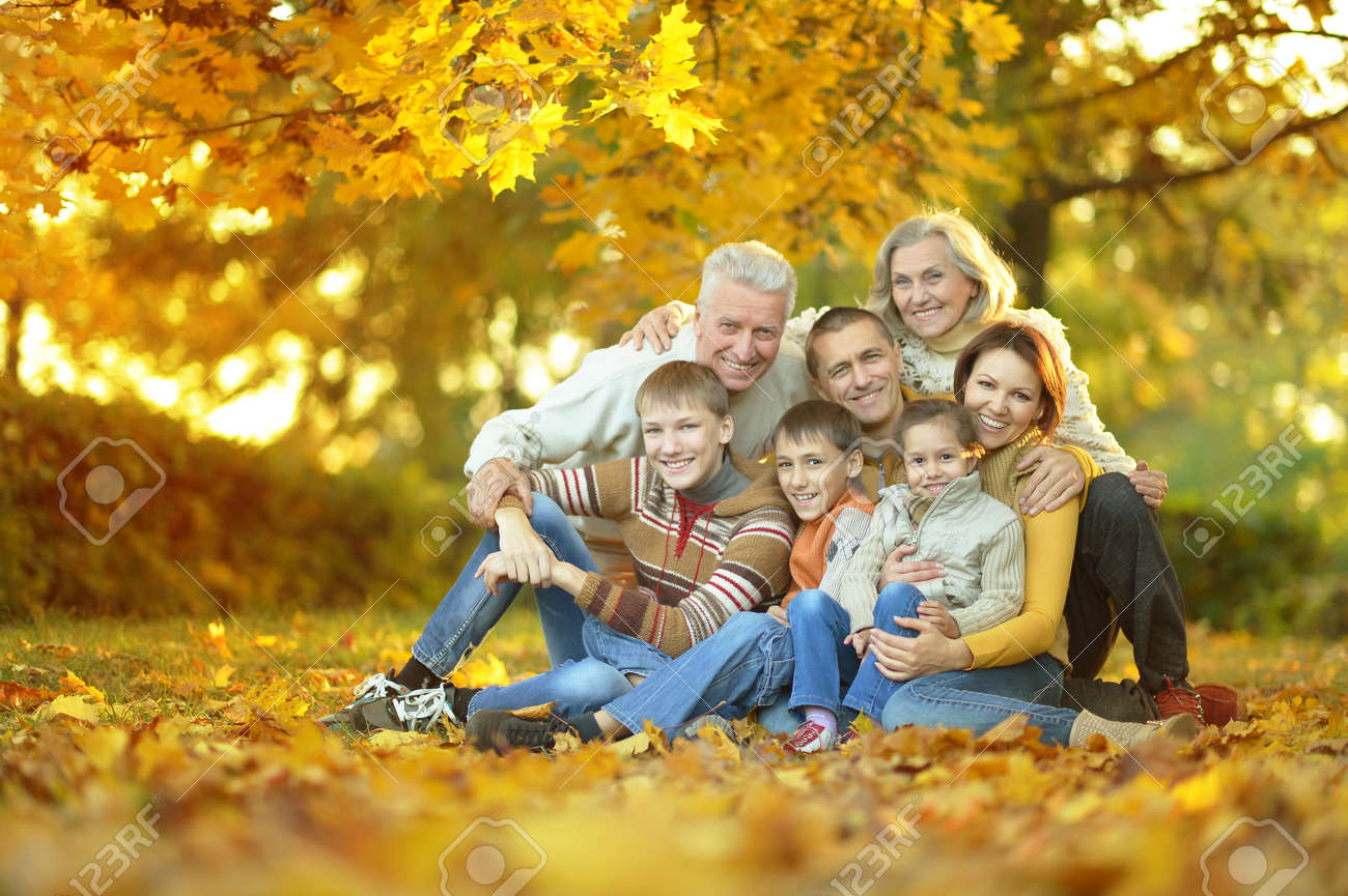 Gluckliche Lachelnde Familie Sitzt Im Herbst Park Lizenzfreie Fotos Bilder Und Stock Fotografie Image