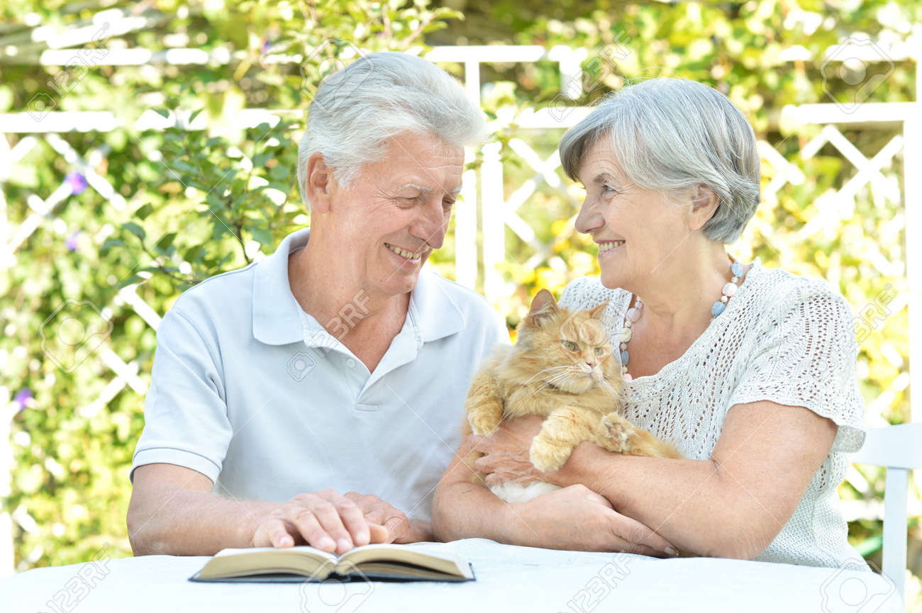 Happy senior couple on the veranda with cat - 53745869 Happy senior couple on the veranda with cat - 53745869