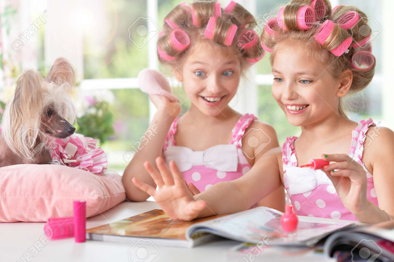 雑誌と自宅の犬とカーラーで髪のかわいい Tweenie の女の子 の写真素材 画像素材 Image