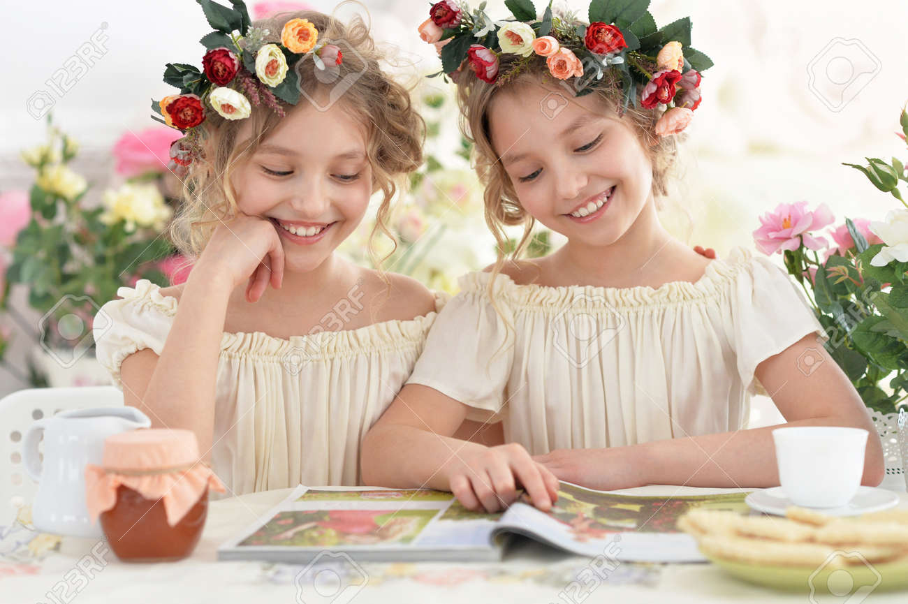 雑誌とティーを自宅の花輪でかわいい Tweenie 女の子 の写真素材 画像素材 Image