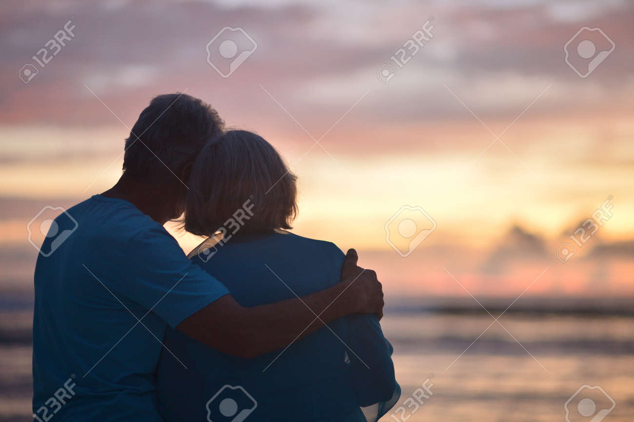 Happy elderly couple rest at tropical beach at sunset,back view - 67076145 Happy elderly couple rest at tropical beach at sunset,back view - 67076145