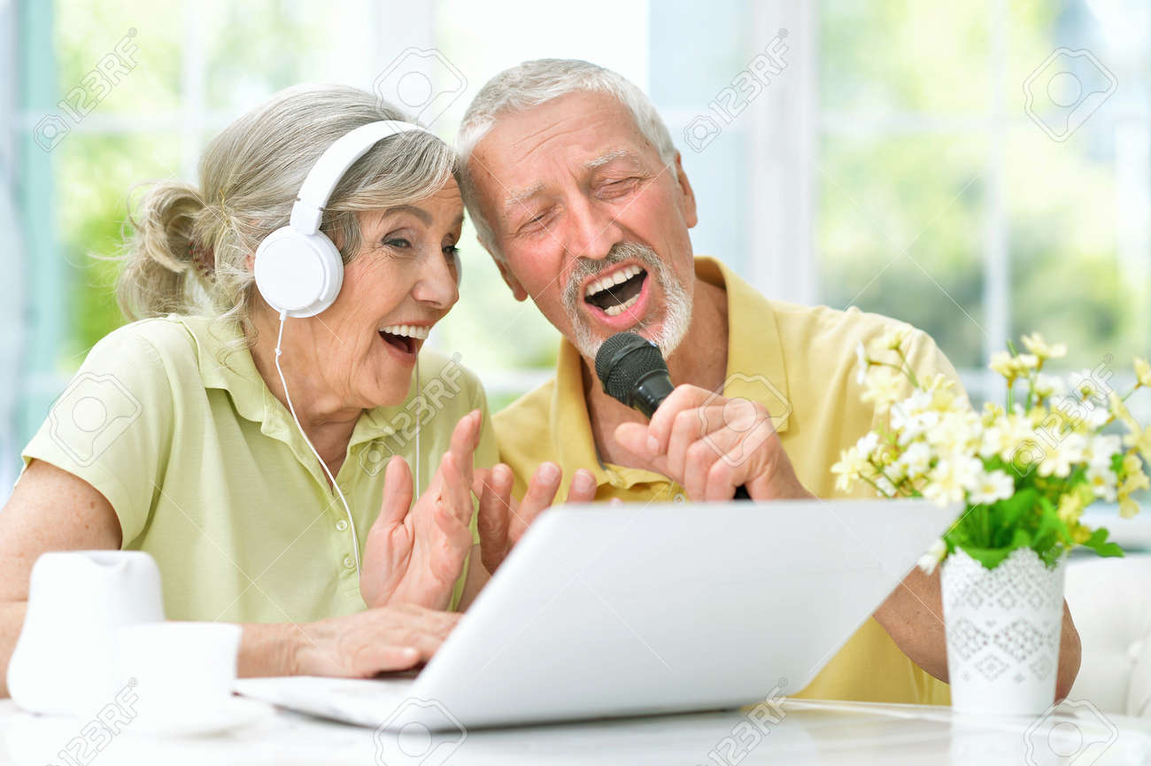 happy senior couple singing karaoke with laptop - 97800547 happy senior couple singing karaoke with laptop - 97800547