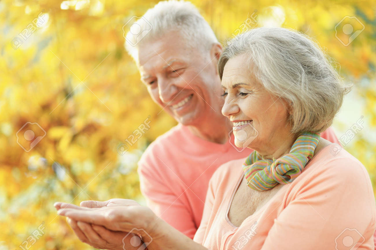 Senior couple in the park showing something - 139291481 Senior couple in the park showing something - 139291481