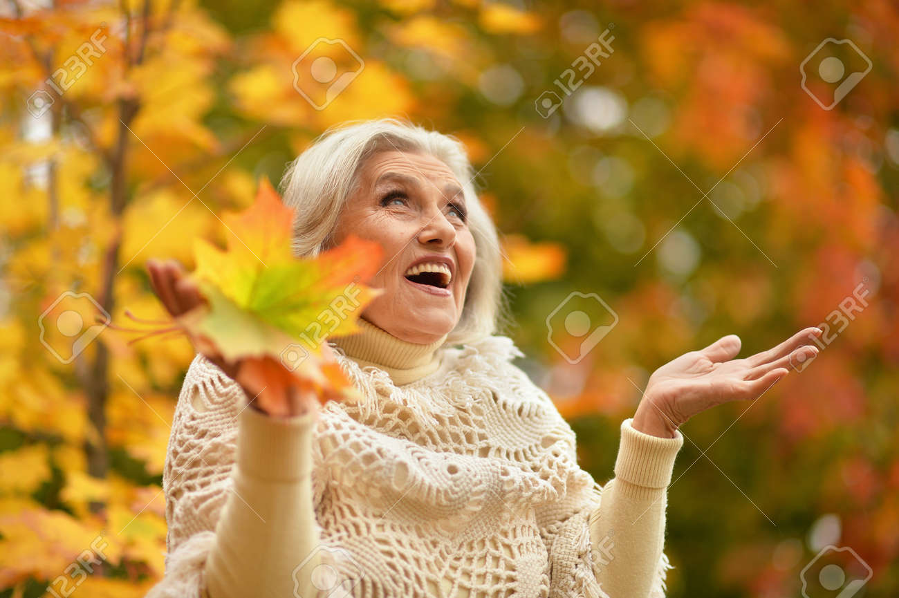 Happy senior beautiful woman in autumn park - 157849614 Happy senior beautiful woman in autumn park - 157849614
