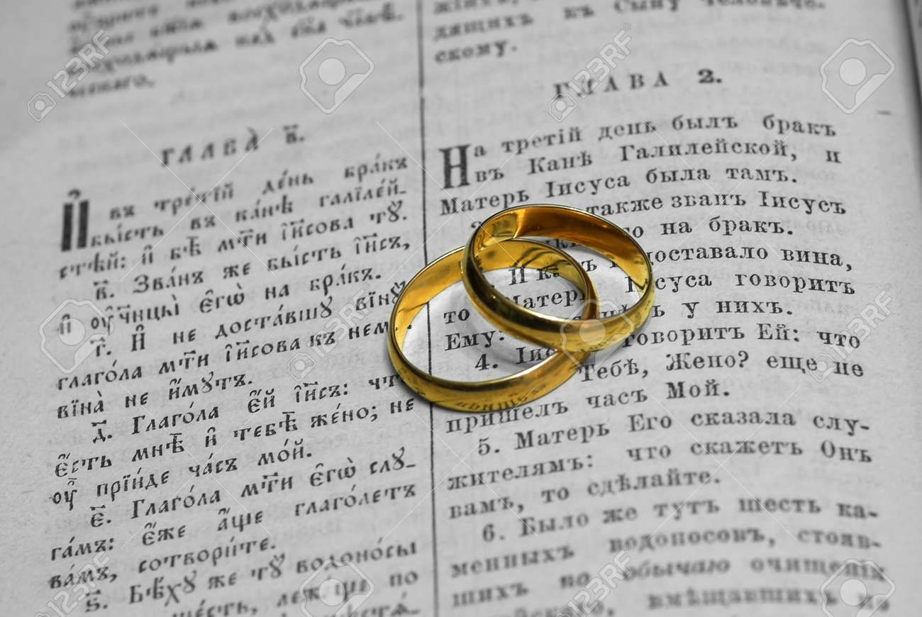 gold wedding rings on sheets of the old russian bible stock photo