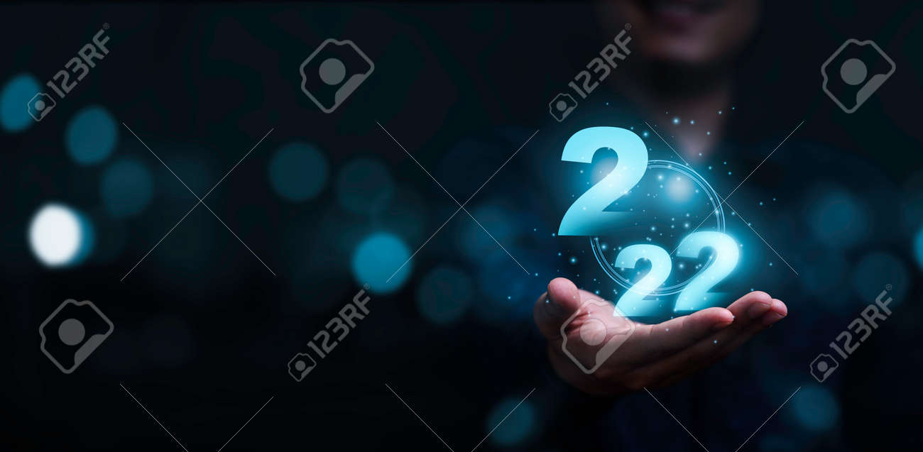 푸른 보케 배경을 가진 가상 2022 번호를 들고 있는 사업가와 메리 크리스마스와 새해 복 많이 받으세요 개념을 위한 복사 공간.  로열티 무료 사진, 그림, 이미지 그리고 스톡포토그래피. Image 175246149