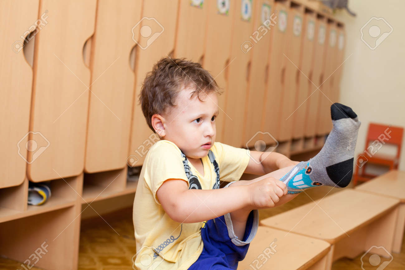 子供が幼稚園で靴下を着てください の写真素材 画像素材 Image