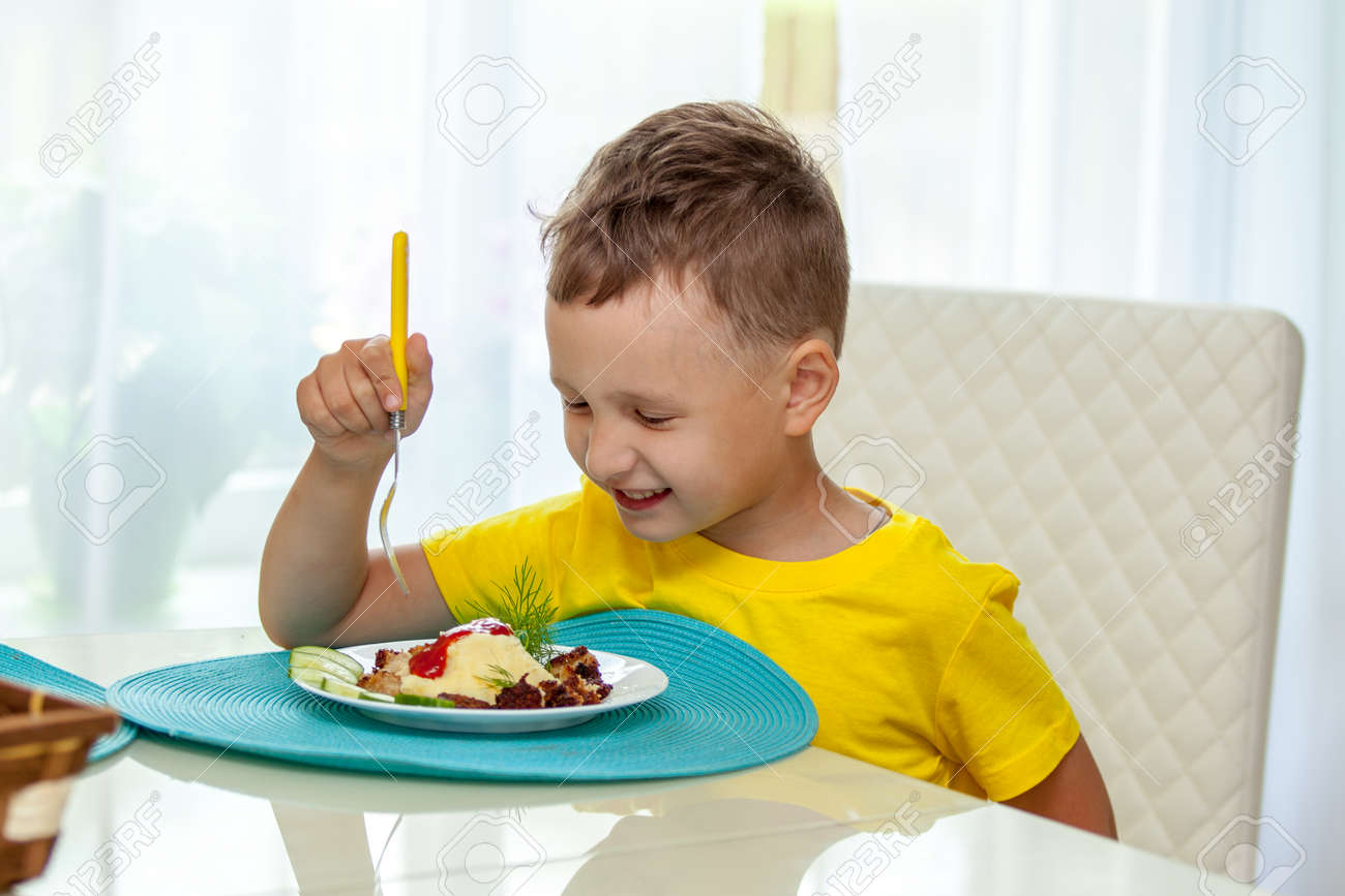 Happy Little Boy Eating A Healthy Dinner At The Table Stock Photo, Picture  and Royalty Free Image. Image 83227149.
