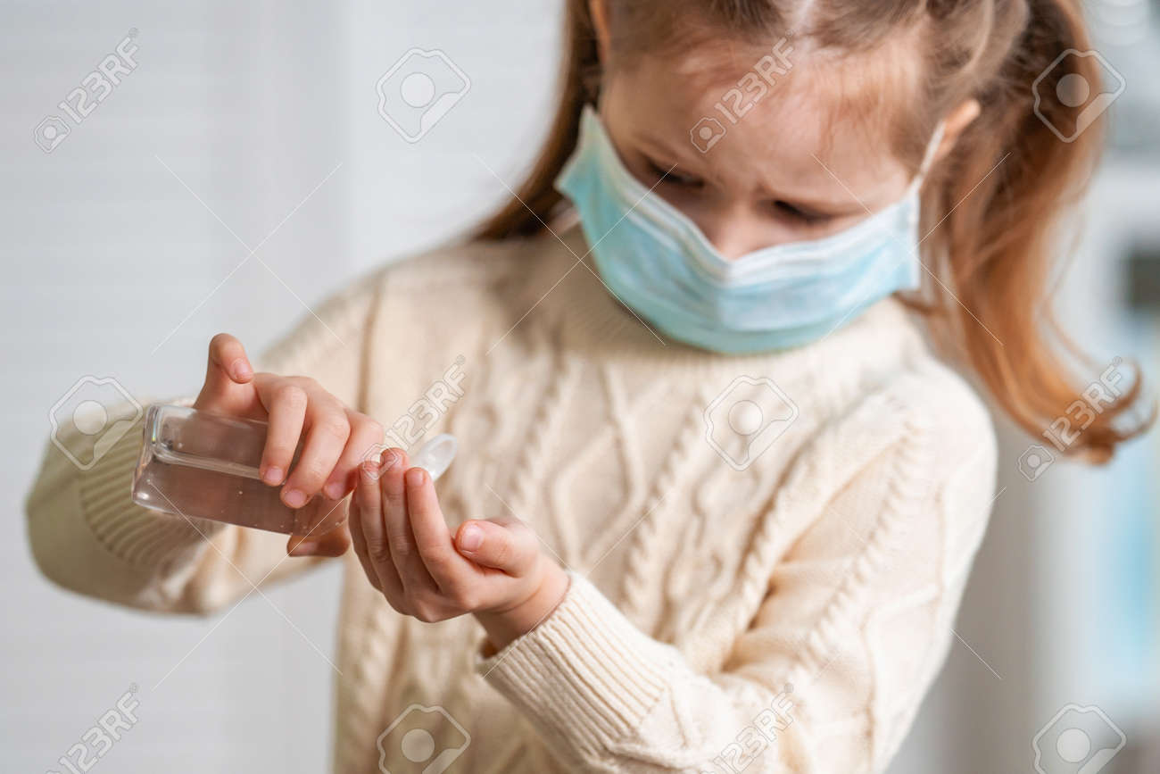 Concept of Covid-19 coronavirus .little girl in mask to protect from the virus and clean hands with alcohol gel sanitizer to stop the outbreak of disease in public place. symptom of an epidemic virus. - 145843965 Concept of Covid-19 coronavirus .little girl in mask to protect from the virus and clean hands with alcohol gel sanitizer to stop the outbreak of disease in public place. symptom of an epidemic virus. - 145843965
