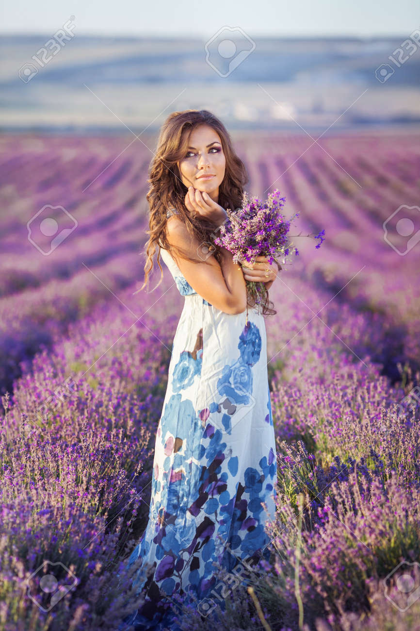 27002877-Mujer-hermosa-que-se-relaja-en-Provence-campo-lila-viendo-la-puesta-de-sol-con-canasta-con-flores-de-Foto-de-archivo.jpg