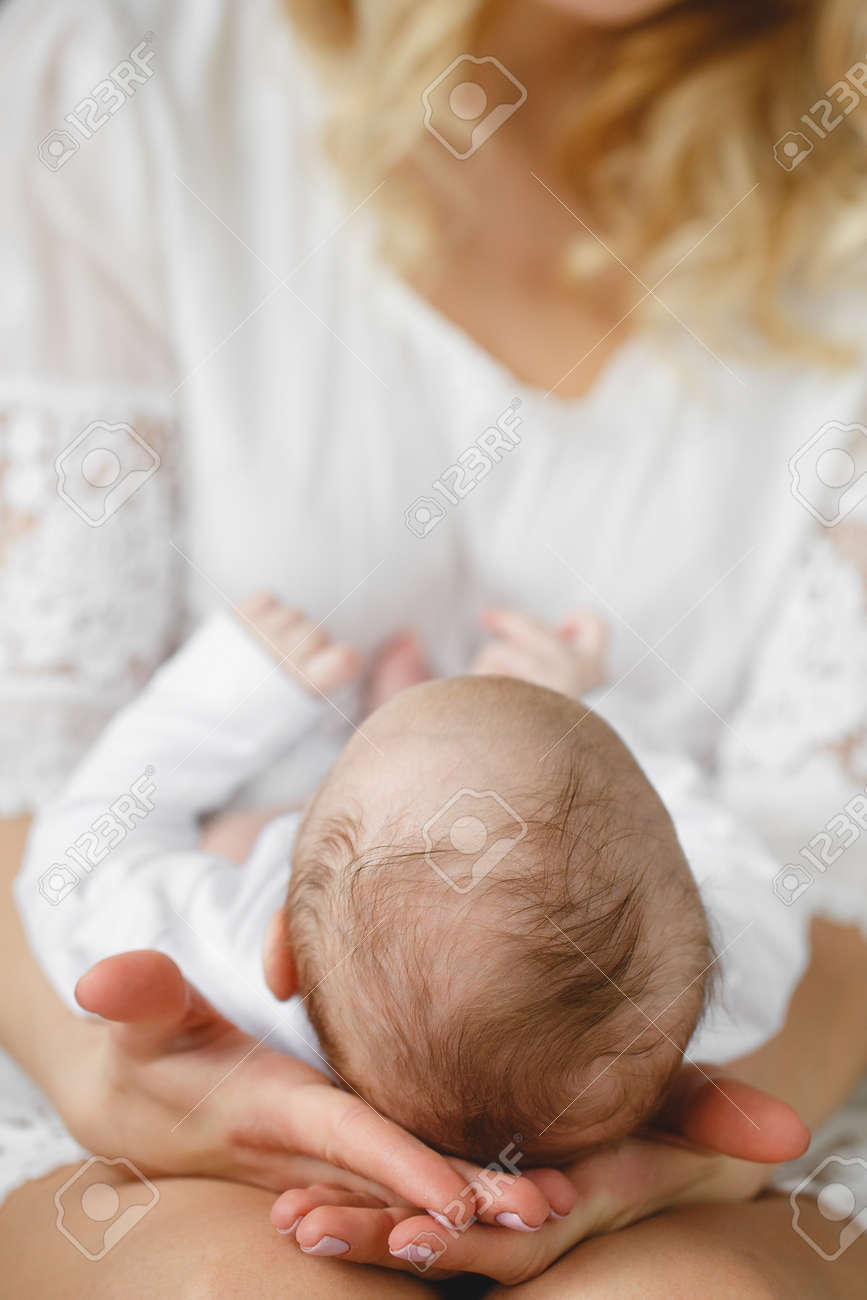 母の手で彼女の生まれたばかりの息子の頭を保持します ママの手で赤ちゃん 愛する母の手かわいい子供生まれたばかりの赤ちゃんの睡眠 の写真素材 画像素材 Image