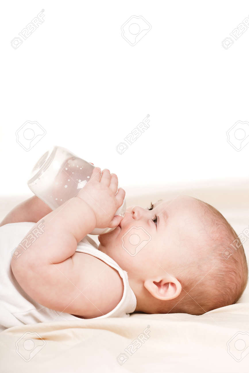 ふわふわの短い髪と茶色の目 小さな男の子にベージュ布団ベッドの白い背景の上にある ボトル丸々 ハンドルを持ち 白い T シャツを着て 瓶から穀物を食べるします の写真素材 画像素材 Image 38033774