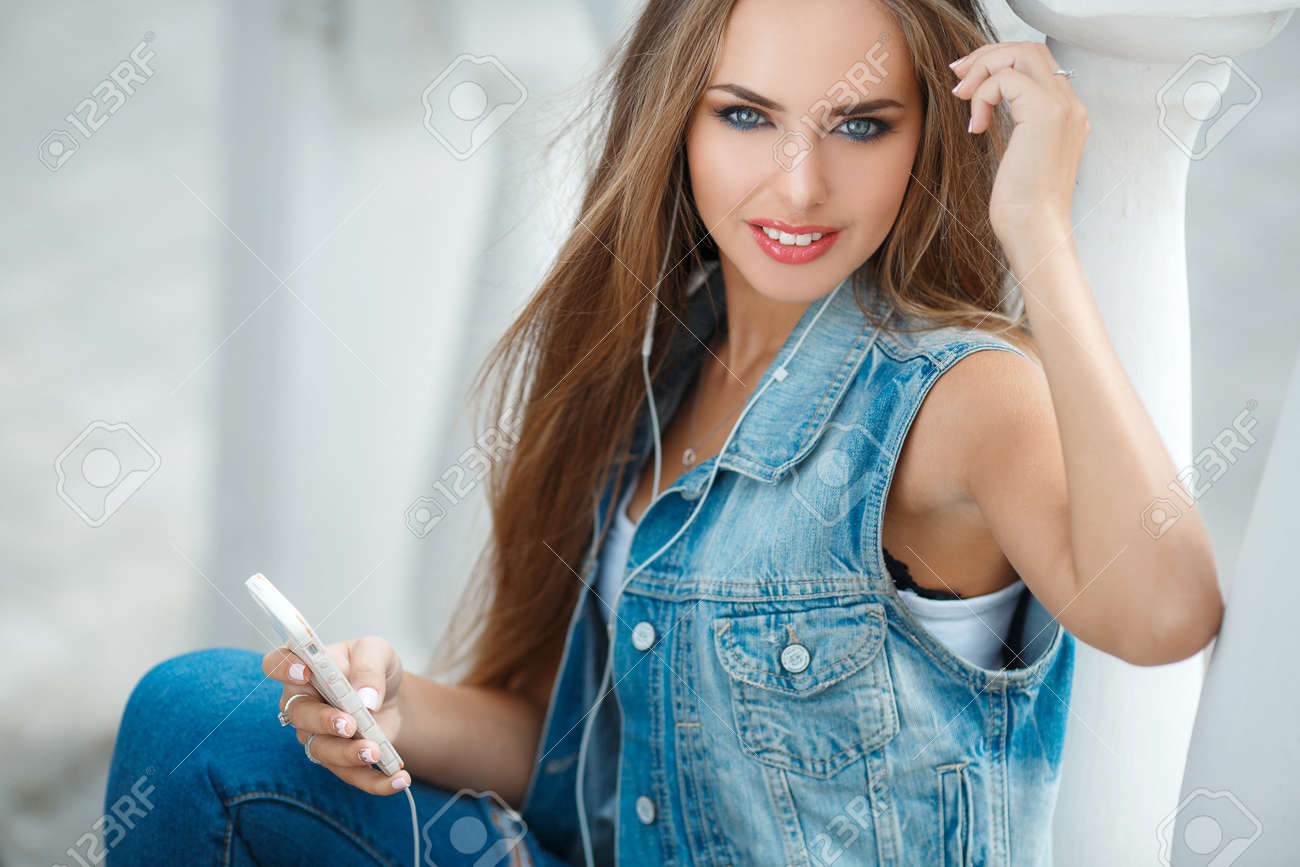 Une Belle Jeune Femme Brune Aux Cheveux Gris Et Longs Yeux Droites Vêtu Dun Bleu Foncé Veste En Jean Sans Manches Assis Sur Les Escaliers Dans Une