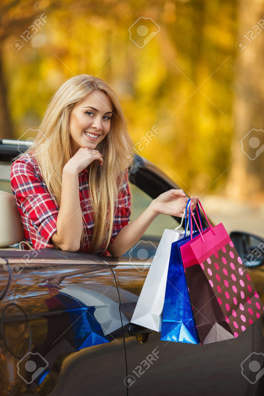 Portrait De La Belle Blonde Aux Cheveux Longs Et Des Yeux Gris Maquillage Léger Et Joli Sourire Vêtu Dune Chemise Rouge à Carreaux Des Sacs En