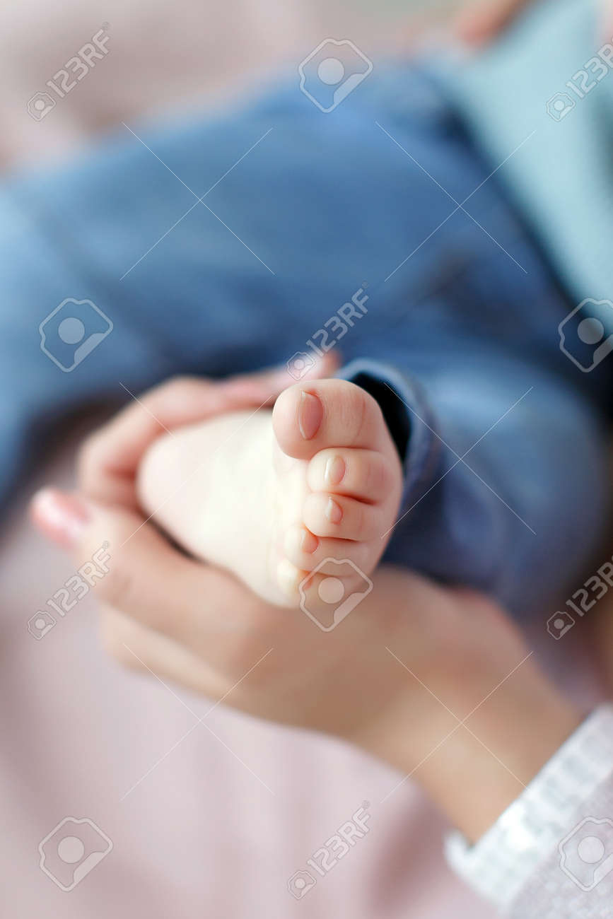 Pieds De Bebe Nouveau Ne Sur Les Palm Parts Du Corps De La Mere Une Jeune Mere Assise Avec Son Fils Nouveau Ne Tendrement Tient Les Mains Bienveillantes De Petits Pieds Pattes Roses De Bebe