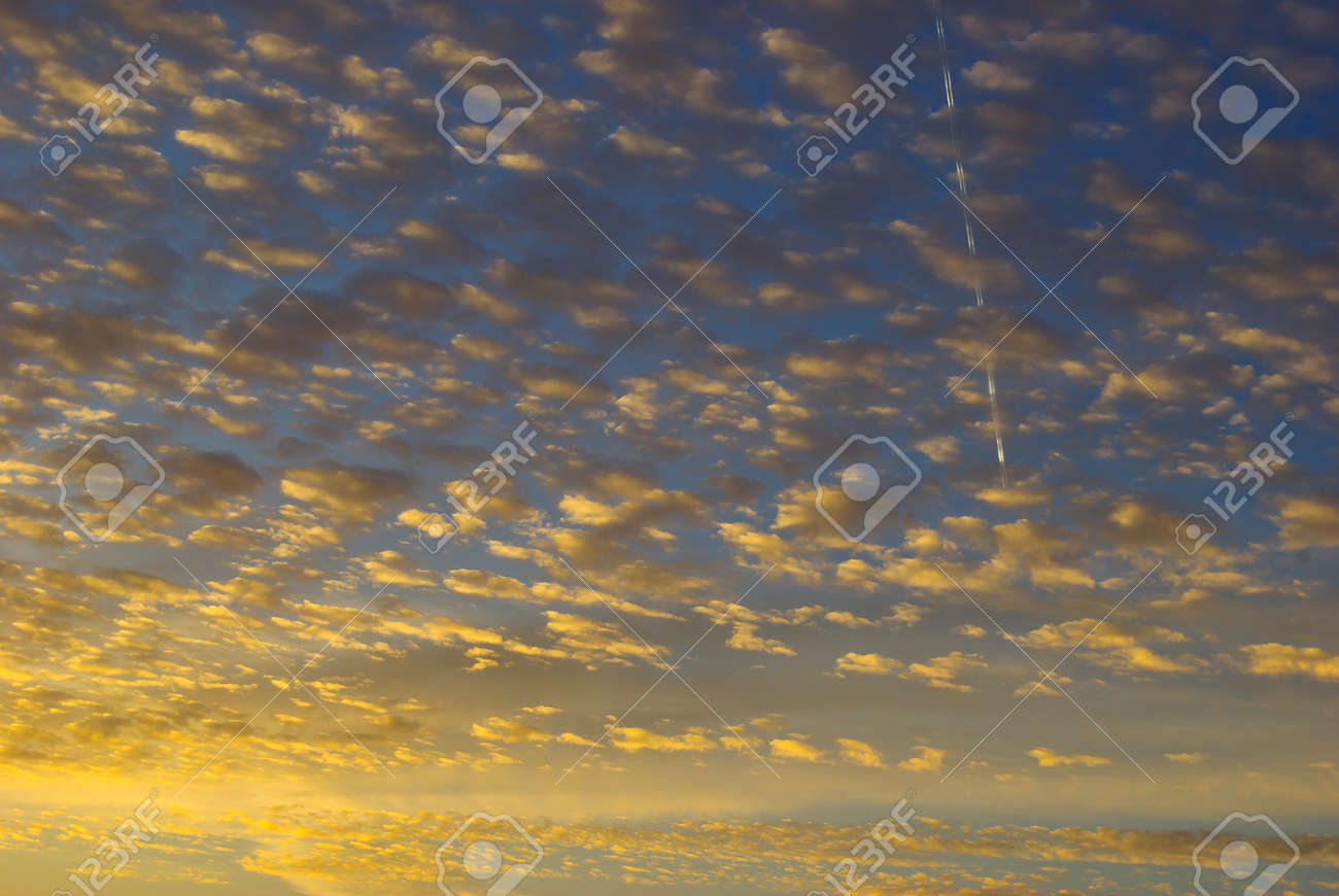 Golden Rays Of Sunset Among The Clouds In The Sky Stock Photo