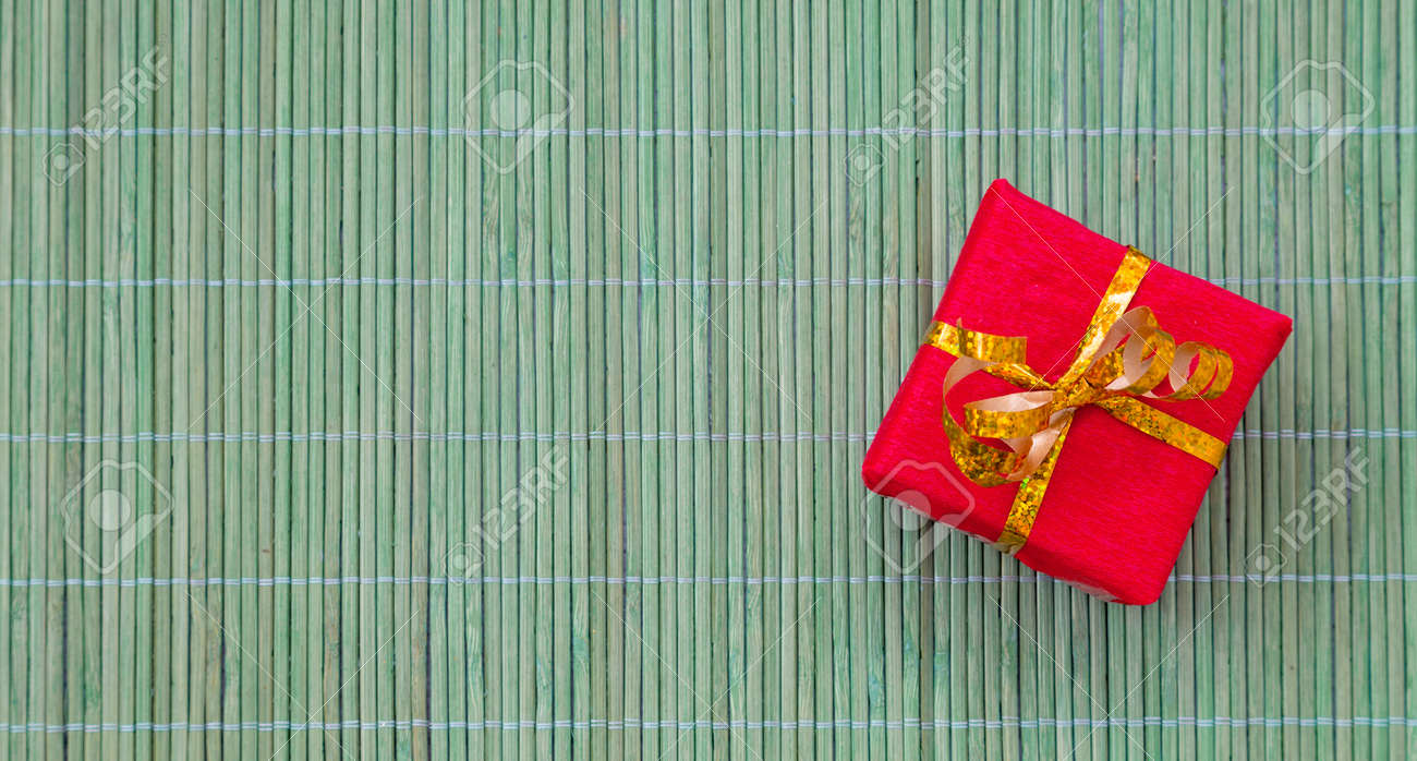 gift box packed in red wrapping paper and decorated with golden
