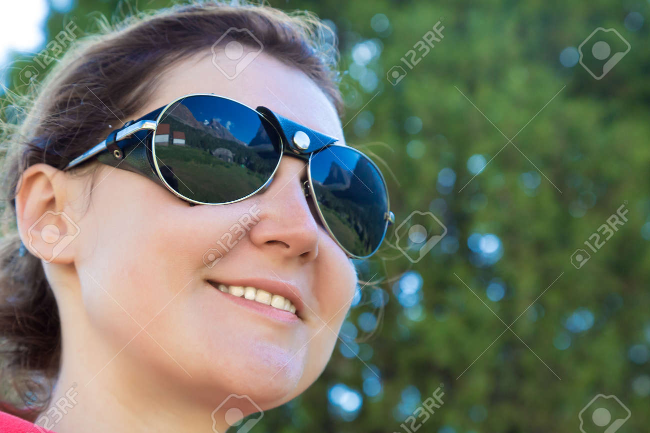 Retrato De Chica Deportiva Sonriente Head Bandana Gafas De Foto de mujer sonriente escalador con gafas de sol sentado