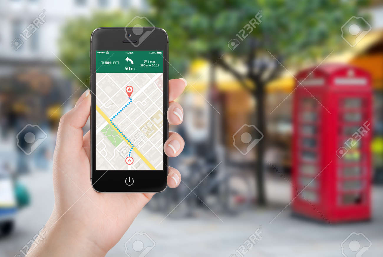 Female hand holding black mobile smart phone with map gps navigation application with planned route on the screen. Blurred street view on the background. - 32493094 Female hand holding black mobile smart phone with map gps navigation application with planned route on the screen. Blurred street view on the background. - 32493094