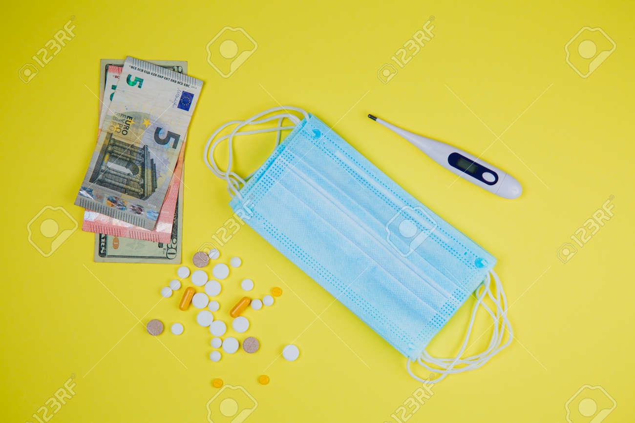 Download Medical Mask And Money Thermometer And Pills On A Yellow Background Stock Photo Picture And Royalty Free Image Image 147426052 PSD Mockup Templates