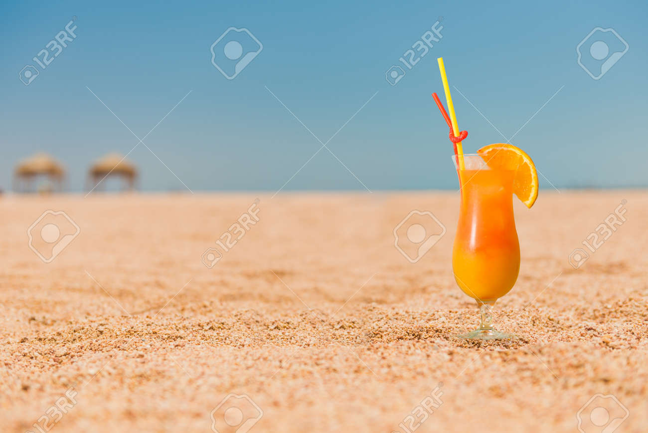 ocktail with orange juice on sandy beach - 137792544 ocktail with orange juice on sandy beach - 137792544
