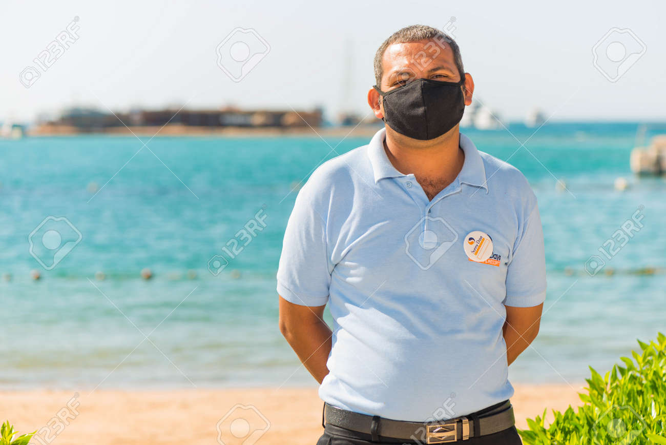 Egypt, Hurghada - 07/15/2020. friendly portrait of egyptian hotel staff in pritective face mask at summer sea beach background - 154118503 Egypt, Hurghada - 07/15/2020. friendly portrait of egyptian hotel staff in pritective face mask at summer sea beach background - 154118503