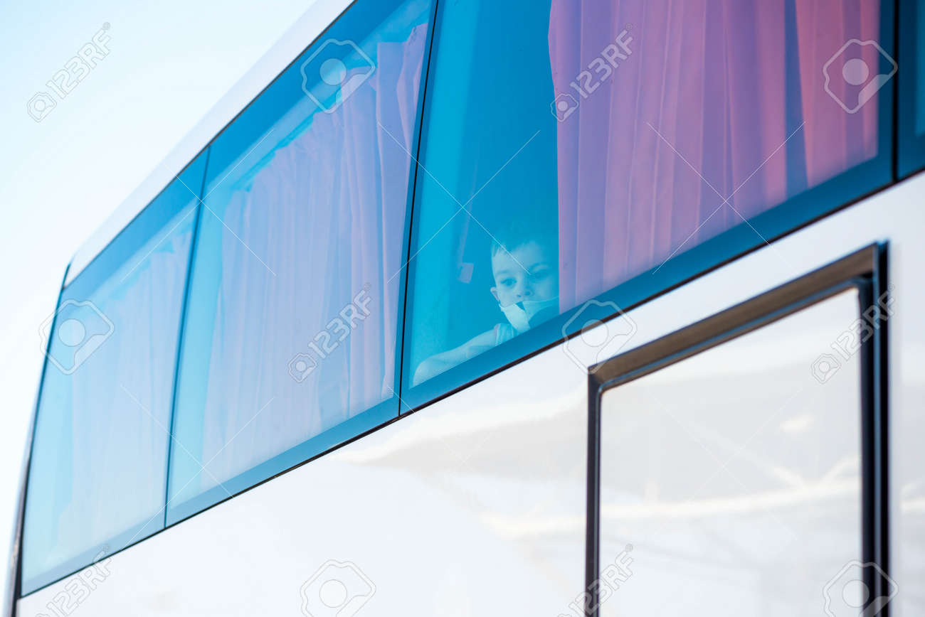 Egypt, Hurghada - 07/11/2020. boy in protective mask looking out from tourist buss window - 154118506 Egypt, Hurghada - 07/11/2020. boy in protective mask looking out from tourist buss window - 154118506