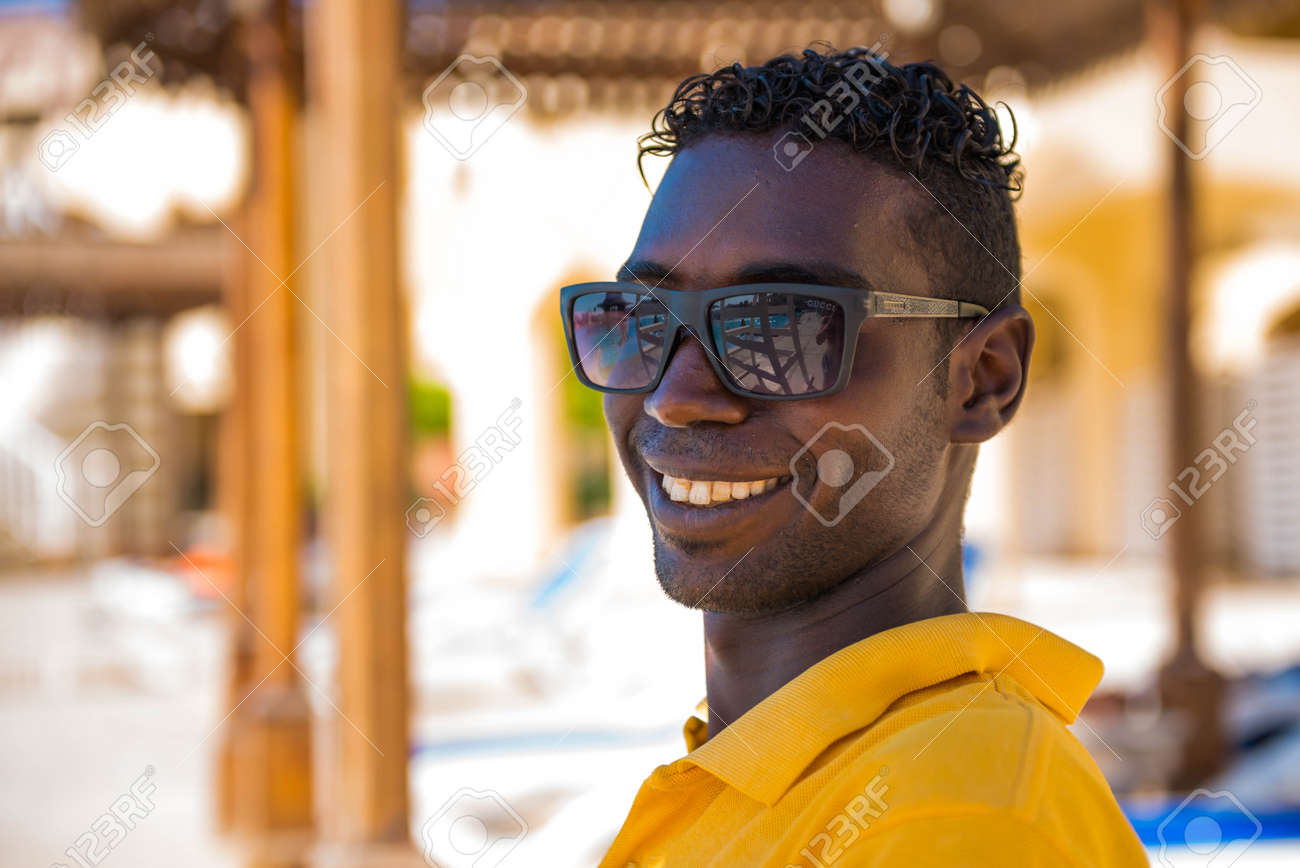 Egypt, Hurghada - 07/16/2020. smiling portrait of egyptian hotel staff lifeguard worker at swimming pool area on background - 154118509 Egypt, Hurghada - 07/16/2020. smiling portrait of egyptian hotel staff lifeguard worker at swimming pool area on background - 154118509