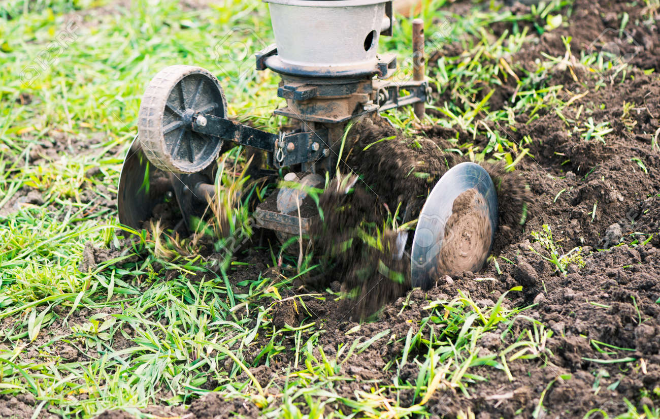 plowing machine working with soil at springtime farmland - 169122100 plowing machine working with soil at springtime farmland - 169122100