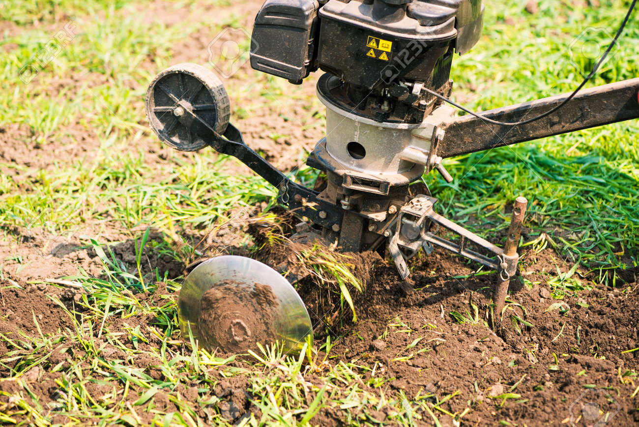 plowing machine working with soil at springtime farmland - 169122104 plowing machine working with soil at springtime farmland - 169122104