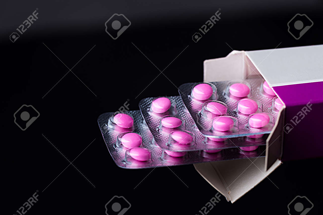 Pinkl ストリップ 紙包装の丸薬 薬 ピンク薬 黒地にピンクの錠剤の 3 つのストリップから医学の背景 の写真素材 画像素材 Image